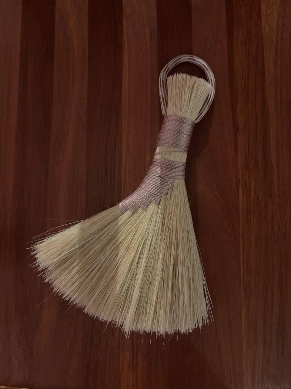 Natural loop-handled whisk broom with pale blush binding.